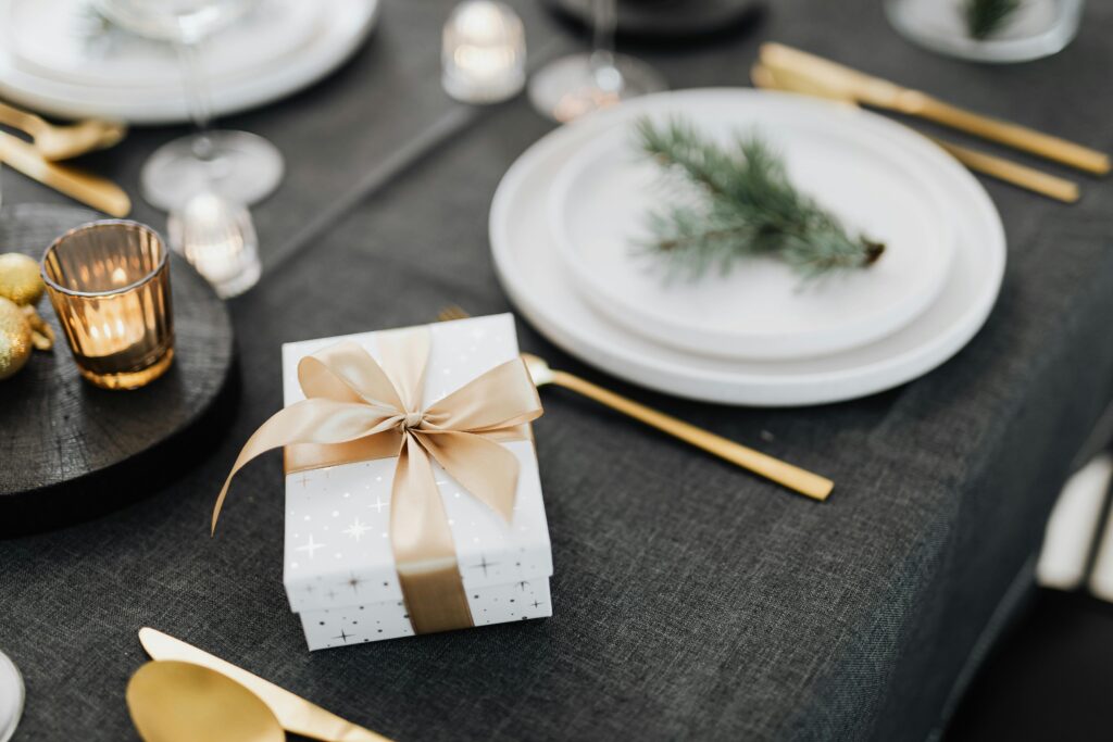 A festive table setting featuring a wrapped gift box with a ribbon, perfect for winter celebrations.